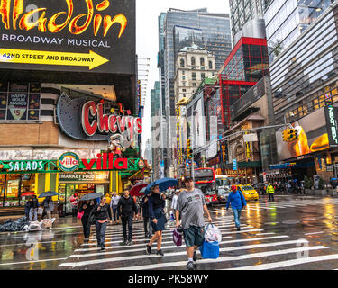 New York, Stati Uniti d'America, 10 settembre 2018. Le persone che attraversano l'Ottava Avenue a 42nd Street a New York City in un giorno di pioggia. Credito: Enrique Shore Foto Stock