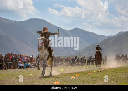 Il lago di Issyk-Kul, Kirghizistan, 6 Settembre 2018: Donna competere nel tiro con l'arco a cavallo gioco Foto Stock