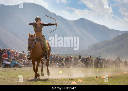 Il lago di Issyk-Kul, Kirghizistan, 6 Settembre 2018: Donna competere nel tiro con l'arco a cavallo gioco Foto Stock