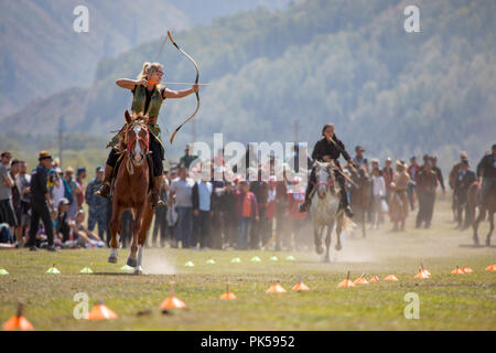 Il lago di Issyk-Kul, Kirghizistan, 6 Settembre 2018: Donna competere nel tiro con l'arco a cavallo gioco Foto Stock