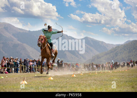 Il lago di Issyk-Kul, Kirghizistan, 6 Settembre 2018: Donna competere nel tiro con l'arco a cavallo gioco Foto Stock