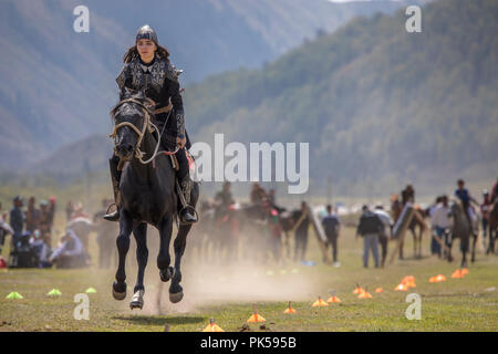 Il lago di Issyk-Kul, Kirghizistan, 6 Settembre 2018: Donna competere nel tiro con l'arco a cavallo gioco Foto Stock