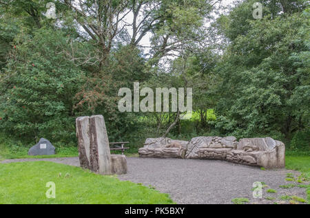 Parkhill legno, Lochwinnoch, Regno Unito - 04 agosto 2018: panca in legno posti a sedere con sculture di piccoli animali che si trovano entro la zona boschiva raffiguranti anima Foto Stock