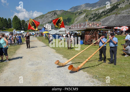 Engstlenalp, Svizzera - 4 August 2018: persone giocare corno delle alpi e portabandiera alla Engstlenalp sulle alpi svizzere Foto Stock