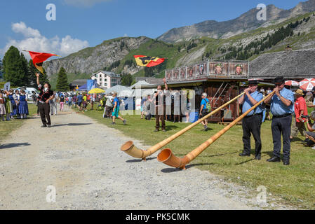 Engstlenalp, Svizzera - 4 August 2018: persone giocare corno delle alpi e portabandiera alla Engstlenalp sulle alpi svizzere Foto Stock