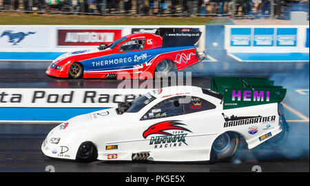 Top Fuel Funny auto drag racing a Santa Pod Raceway. Jason Phelps in una Dodge Stratus nearside v Kevin Chapman in una Ford Mustang lato lontano. Foto Stock