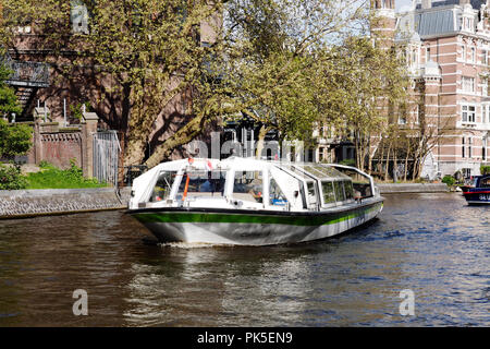 Amsterdam canal scena con grandi tour barche sul canale principale dalla Stadhouderskade. Queste imbarcazioni offrono escursioni lungo i canali e il porto per i turisti. Foto Stock