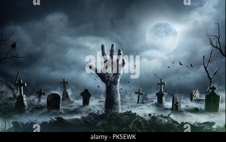 Mano di zombie che aumenta di un cimitero di notte spooky Foto Stock