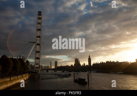 Londra, Inghilterra, 30 ottobre 2013: La Casa del Parlamento e il London Eye profilarsi da un tramonto dorato. Foto Stock