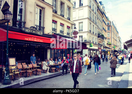 La gente a piedi sulla famosa Rue Montorgueil street a Parigi. Un caffè tradizionale / bistro posto è in background. Foto Stock