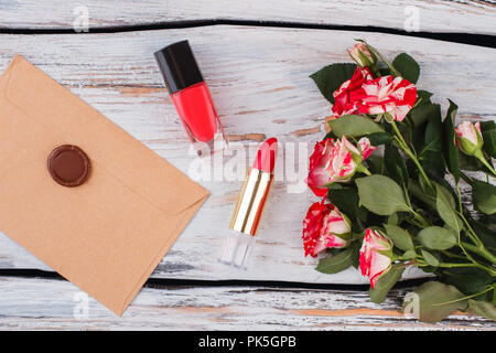 Fiori, gli accessori per il trucco e post mail con guarnizione cera timbro. Legno bianco sullo sfondo. Foto Stock