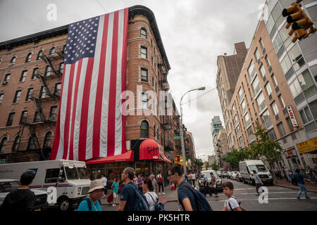 Un gigante 60 piedi da 30 piedi bandiera americana pende dal lato di un edificio di appartamenti in Piccola Italia a New York venerdì 31 agosto 2018. La bandiera, in onore di coloro che hanno lavorato al sito del World Trade Center dopo 9/11, è stata visualizzata ogni anno sin dal 2002 ed è orchestrato da John e Denise Casalinuovo con l aiuto di volontari. Sarà sul display sul lato dell'edificio che possiede Casalinuovo fino al Sabato dopo l'11 settembre, 15 settembre quando sarà abbassato e ripiegato correttamente per lo stoccaggio. (© Richard B. Levine) Foto Stock