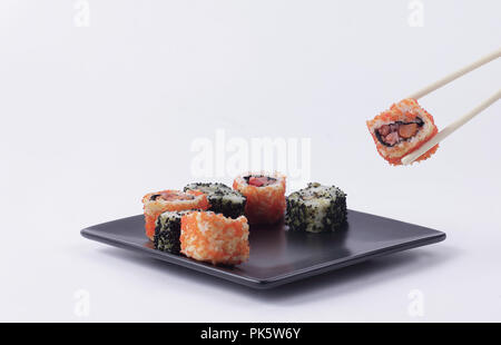 Il Sushi e rotoli. Il set viene servita su una piastra nera Foto Stock