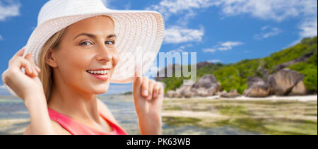 Ritratto di donna sorridente nel cappello per il sole sulla spiaggia Foto Stock