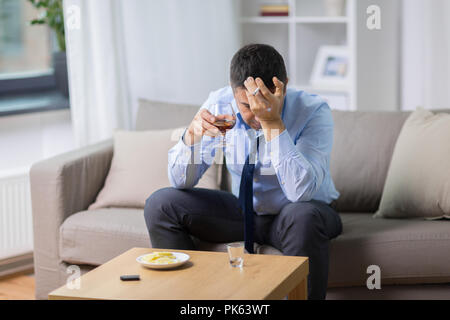 Uomo ubriaco bere alcolici e fumare sigaretta Foto Stock