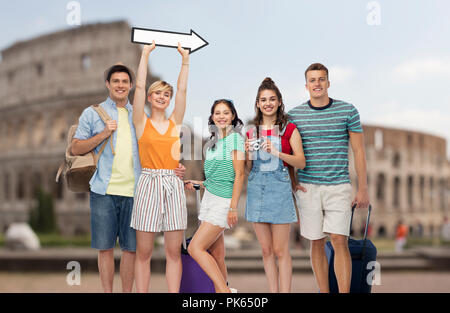 Amici con borse da viaggio e freccia sul Colosseo Foto Stock