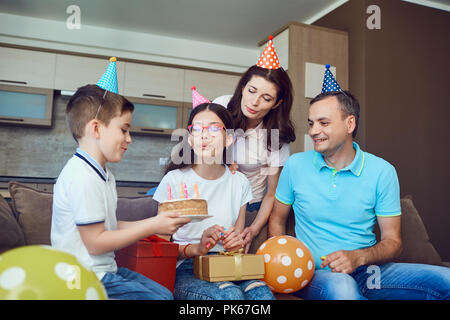 Famiglia festeggia il compleanno con una torta di compleanno. Foto Stock