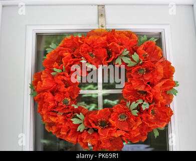 Rosso ghirlanda fiorita sulla porta Foto Stock