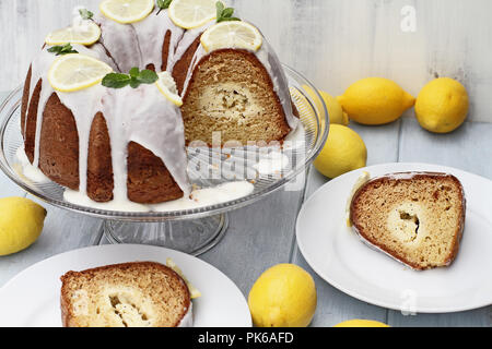 Al di sopra di colpo di crema di limone formaggio bundt torta con crema di formaggio ripieno nel centro con vicino a fette. Estrema profondità di campo con il selettivo Foto Stock