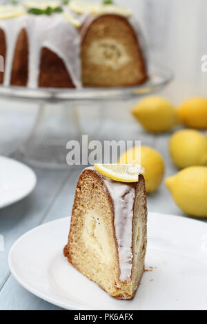 Fettina di limone crema di formaggio bundt torta con crema di formaggio ripieno nel centro. Estrema profondità di campo con il fuoco selettivo sulla parte anteriore della torta. Foto Stock