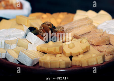 Varietà di formaggi su tavola di legno con albicocca e noci. Foto Stock