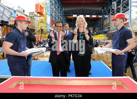 11 settembre 2018, Meclemburgo-Pomerania occidentale, Rostock: Tan Sri Lim Kok Thay (M a sinistra), Presidente e CEO di Genting Hong Kong, e Manuela Schwesig (SPD), il primo ministro del Land Meclemburgo-Pomerania occidentale, messo monete in uno dei vettori sotto la prima sezione durante la festosa chiglia-cerimonia di posa per la prima classe globale nave da crociera presso il cantiere navale a Warnemünde. Il 'Global 1' sarà in grado di ospitare fino a 9.500 passeggeri, più di qualsiasi altra nave da crociera sul mercato internazionale. Il lussuoso rivestimento sarà 342 metri di lunghezza e 20 ponti di alta. Foto: Bernd Wüstneck/dpa Foto Stock