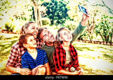 La famiglia felice di prendere una selfie nel parco Foto Stock