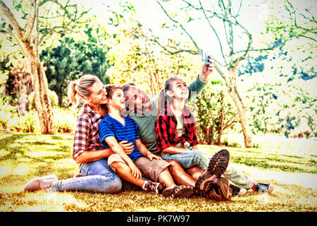 La famiglia felice di prendere una selfie nel parco Foto Stock