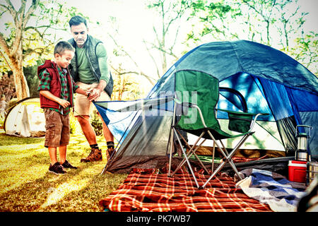 Padre e figlio impostazione della tenda al campeggio Foto Stock