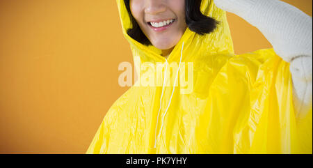 Immagine composita della donna che indossa un impermeabile giallo contro uno sfondo bianco Foto Stock