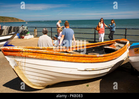 Regno Unito, Inghilterra, Yorkshire, Filey, Coble sbarco, i visitatori in appoggio su barche nella luce del sole Foto Stock