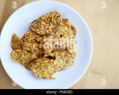 Tempeh fritto in una piastra bianca sulla superficie di legno. Foto Stock