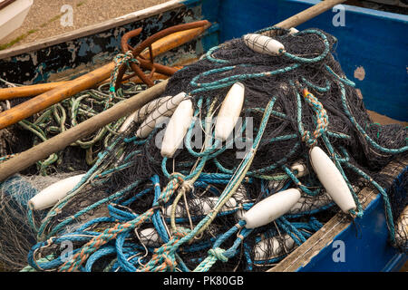 Regno Unito, Inghilterra, Yorkshire, Filey, Coble atterraggio, reti dei pescatori, e galleggia in barca da pesca Foto Stock