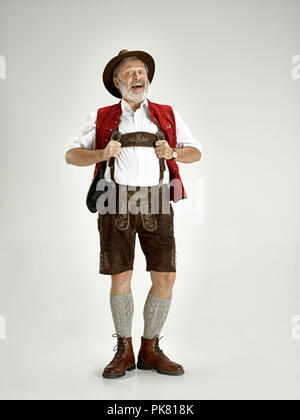 Ritratto di Oktoberfest senior uomo in hat, indossando tradizionali bavaresi vestiti in piedi a tutta lunghezza in studio. La celebrazione, oktoberfest, festival concept Foto Stock