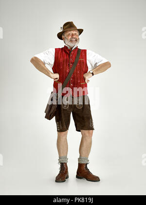 Ritratto di Oktoberfest senior uomo in hat, indossando tradizionali bavaresi vestiti in piedi a tutta lunghezza in studio. La celebrazione, oktoberfest, festival concept Foto Stock