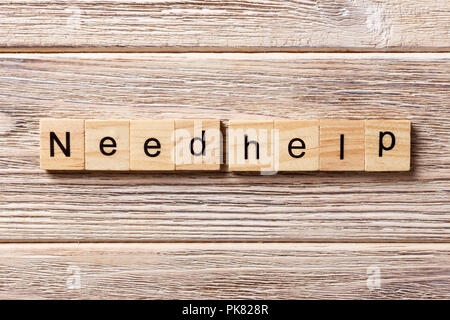 Hai bisogno di aiuto per parola scritta sul blocco di legno. Bisogno di aiuto del testo in tabella, concetto. Foto Stock