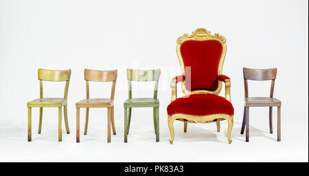Un trono tra semplici sedie. Foto Stock