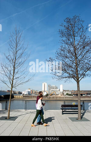 Giovane uomo e donna che cammina a battersea reach, accanto a ther fiume Tamigi vicino a Wandsworth Bridge, Londra, Inghilterra Foto Stock
