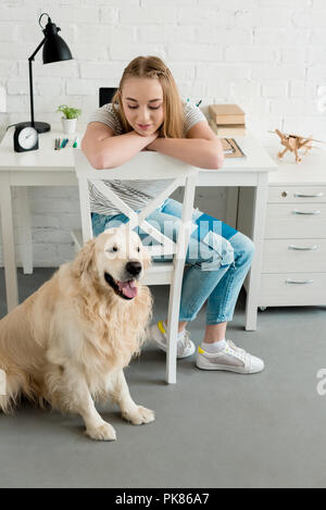 Sorridente ragazza teen di trascorrere del tempo a casa con il suo cane Foto Stock