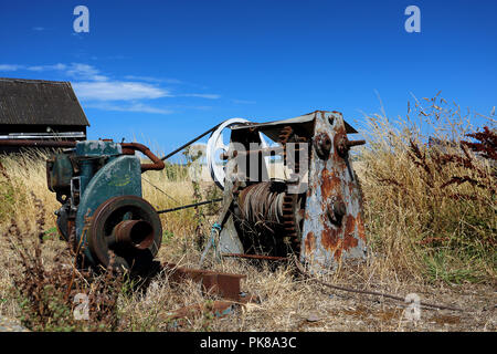 Ridondante verricello vecchi macchinari abbandonati in un campo accanto alla spiaggia di Aldeburgh, Suffolk, Regno Unito Foto Stock