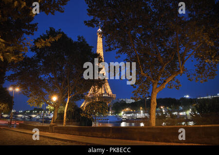 Quay a Parigi di notte contro una torre Eiffel come sfondo. Foto Stock