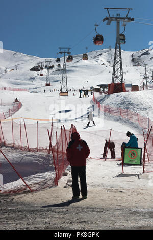 Persona sostare di fronte alla Valle Nevado Ski lift , alcune persone intorno a godere l'inverno. Si tratta di un luogo ideale per lo sci e lo snowboard in montagne andine Foto Stock