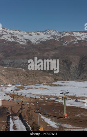 Vista di ski lift in Farellones parchi, con alcune montagne innevate all'indietro. Si trova a 36 km da Santiago e anche vicino ad altre località sciistiche Foto Stock