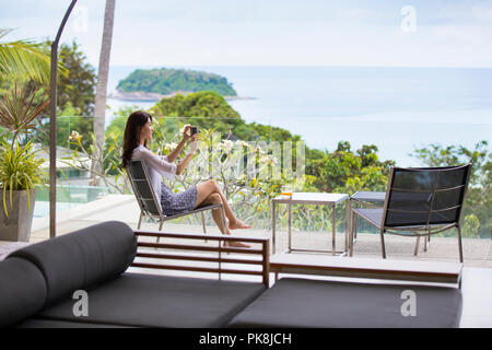 Felice giovane donna rilassante sul balcone Foto Stock