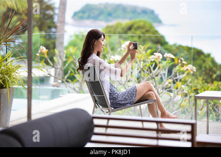 Felice giovane donna rilassante sul balcone Foto Stock