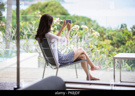 Felice giovane donna rilassante sul balcone Foto Stock