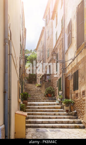Stretto vicolo ripido con gradini in storico villaggio spagnolo Foto Stock