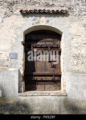 Antica porta di legno con grandi cerniere di ferro, reggette e bulloni in le rimanenti pareti della città di Kaufbeuren, una piccola cittadina in Algovia, Baviera. Foto Stock