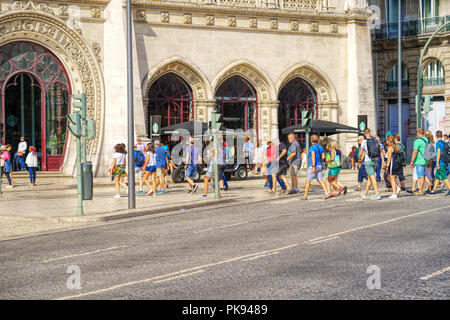 Le porte di ingresso al Rossio stazione ferroviaria, popolo di fronte allo stile Neo-Manueline facciata di Rossio stazione ferroviaria di Lisbona Foto Stock