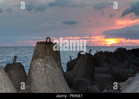 Wavebrakers granito in un golfo di Riga, Lettonia dopo il tramonto nel mese di agosto Foto Stock